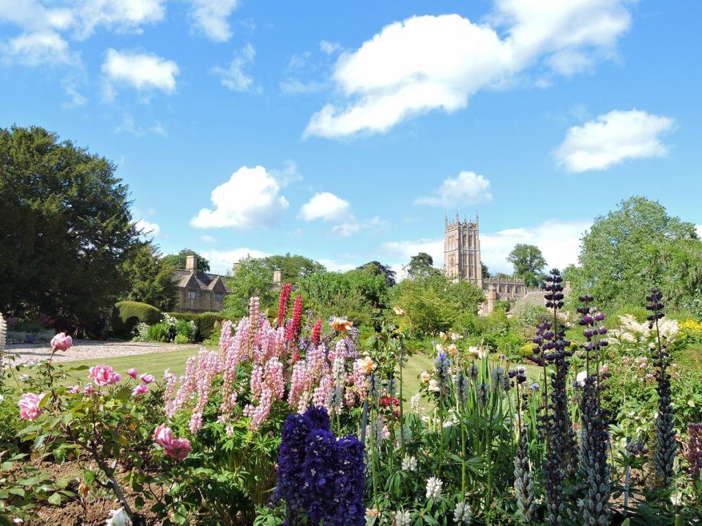 lush flower garden stone abbey in background