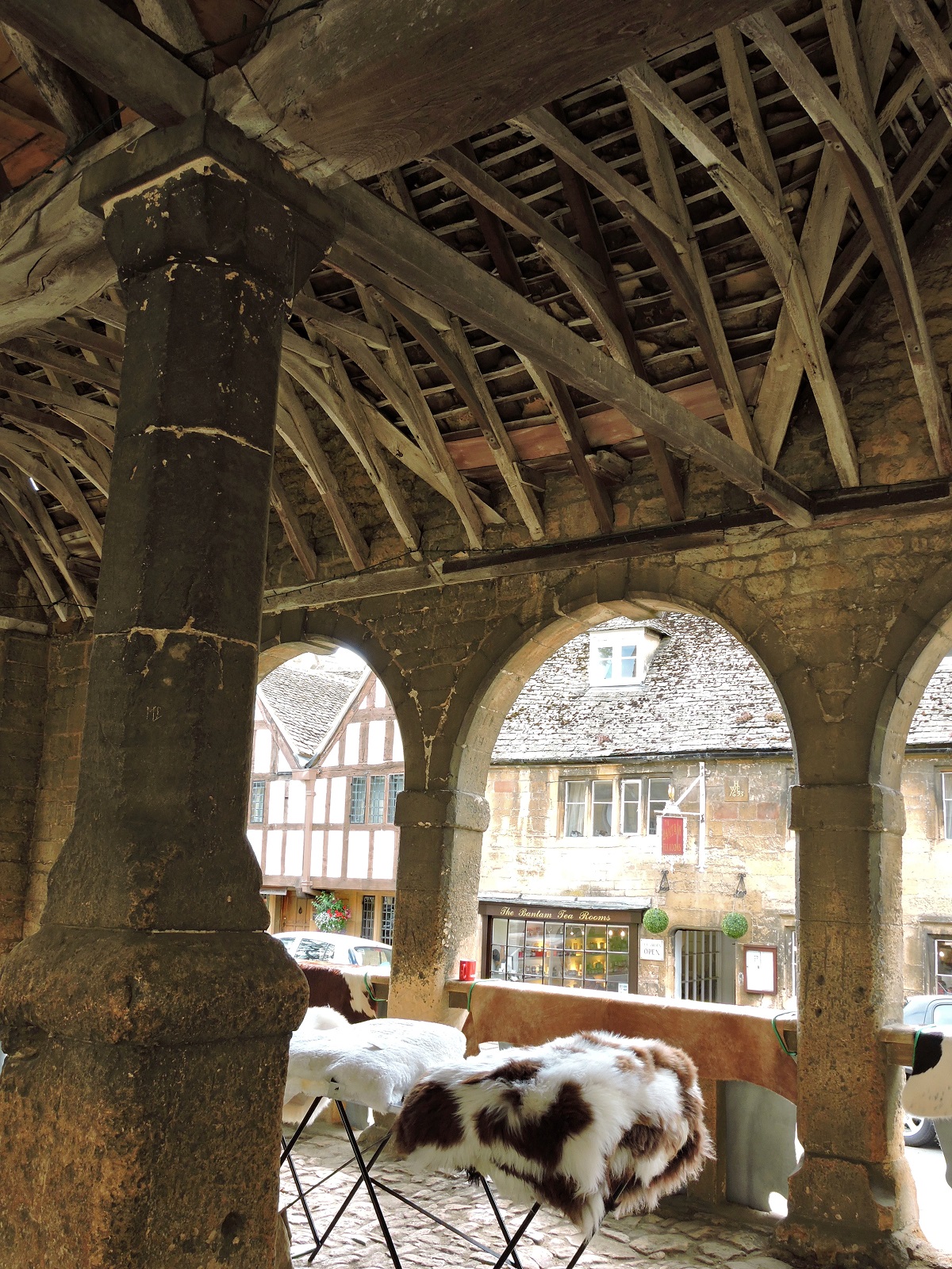 old stone and timber market hall with sheep skins for sale