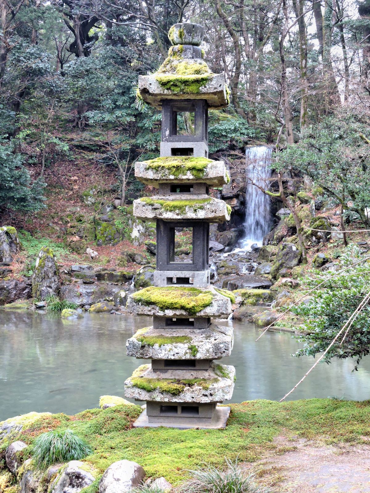 stone pagoda and waterfall with small pond