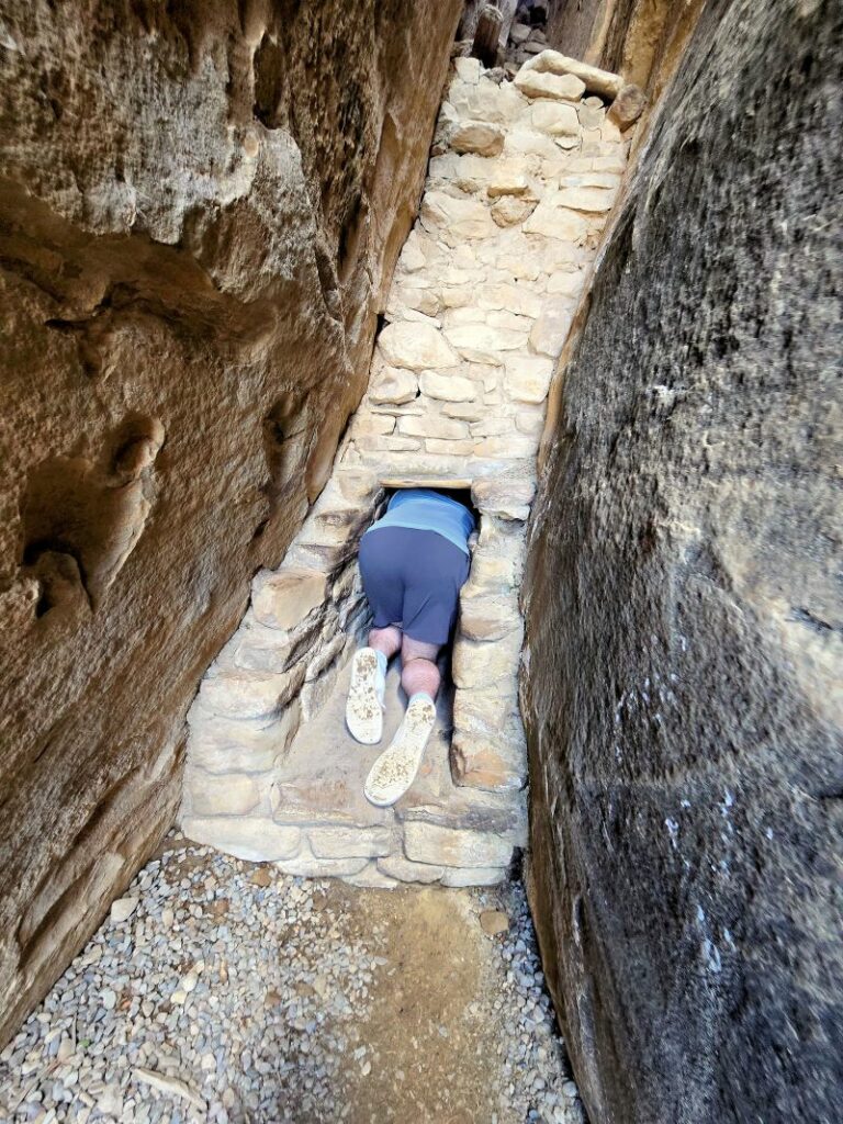 man crawling through tunnel at balcony house